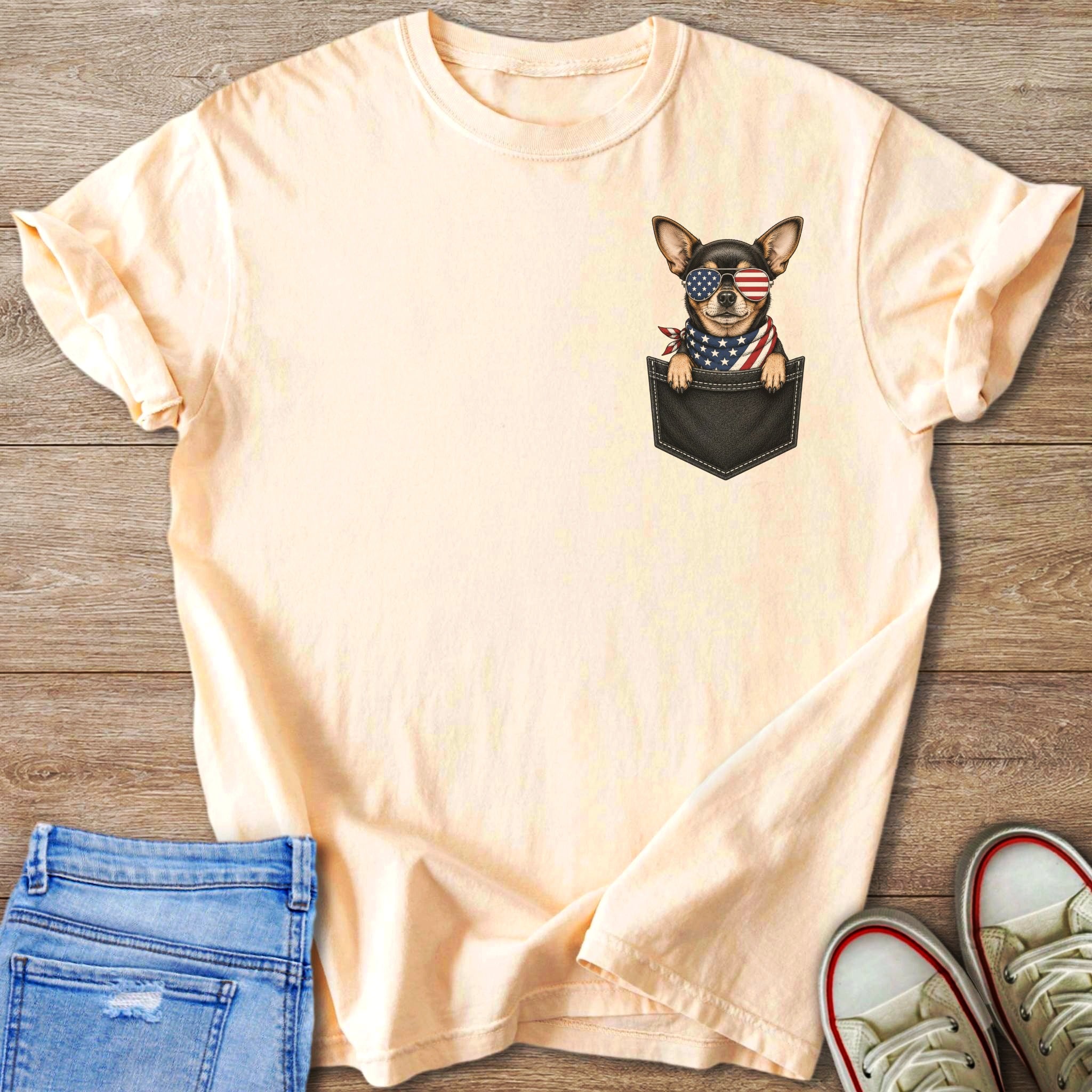 Peach t-shirt with a chihuahua wearing American flag sunglasses and bandana in a pocket.