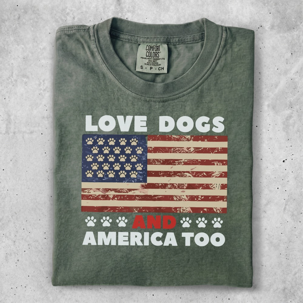 Green t-shirt with American flag, paw prints, and text "LOVE DOGS AND AMERICA TOO".