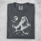 Dark grey t-shirt with white graphic of a Pomeranian dog on a rocky outcrop overlooking a forest and moonlit sky.