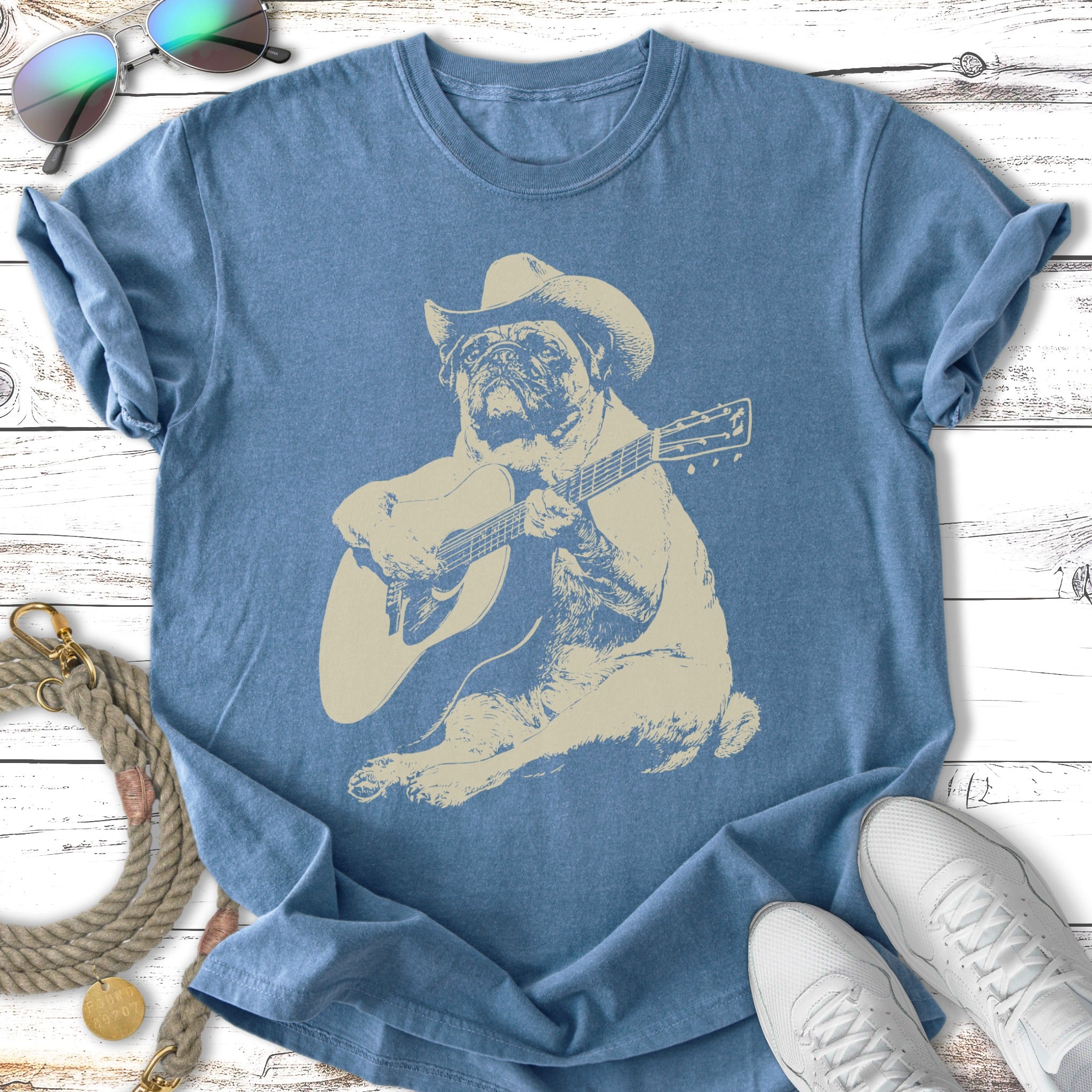 Pug wearing a cowboy hat plays an acoustic guitar.