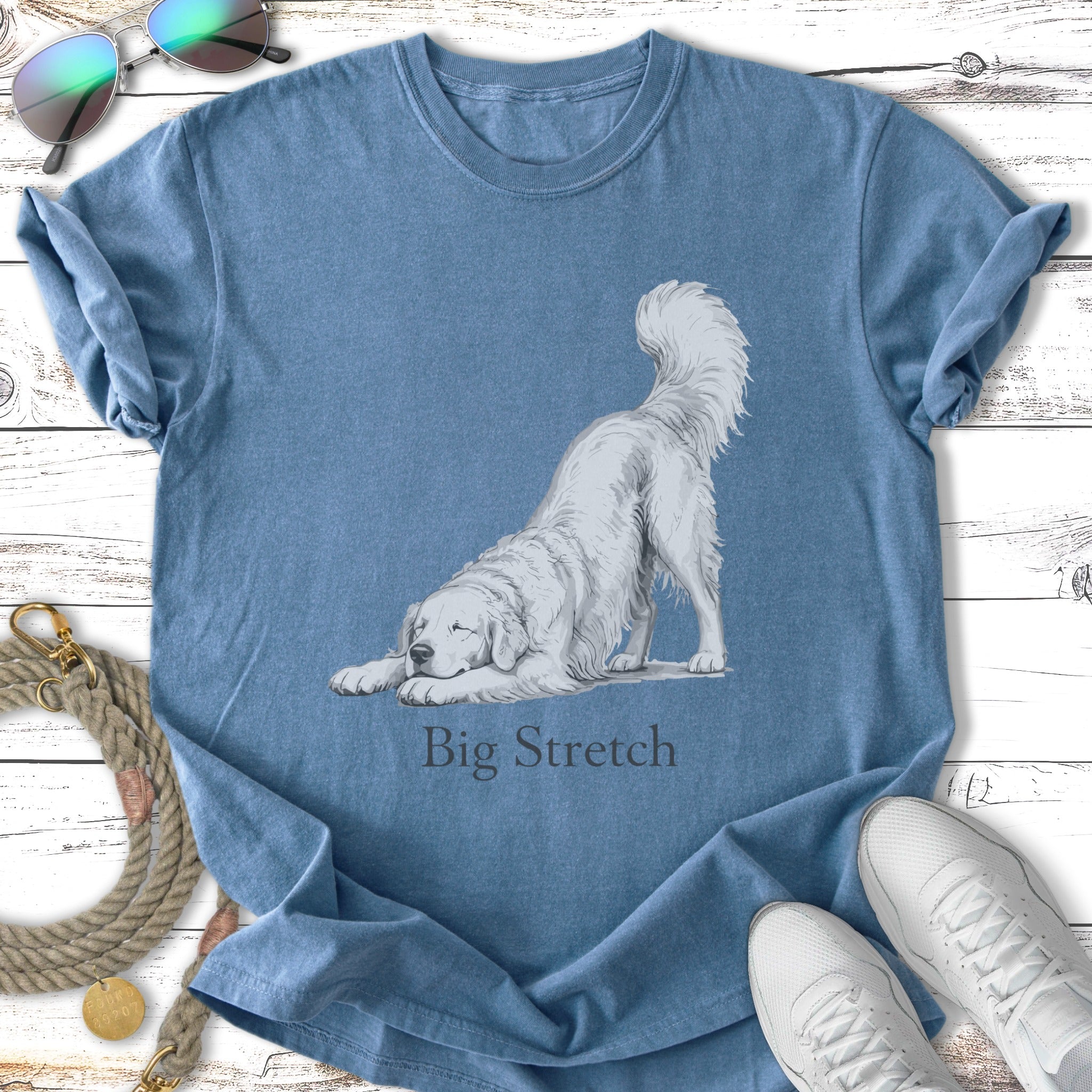 White dog doing a "Big Stretch" pose on a blue t-shirt.