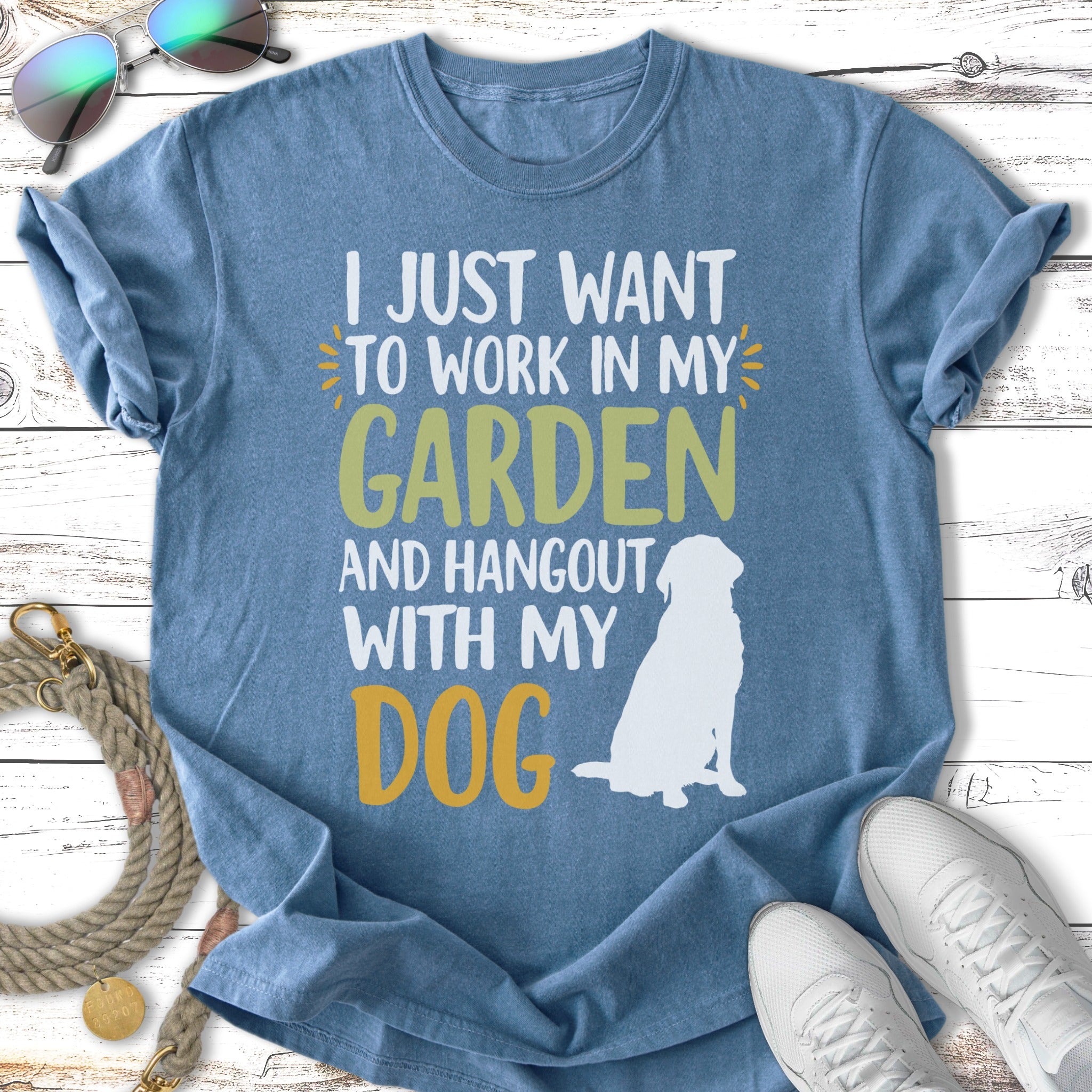 Blue t-shirt with white and yellow text about gardening and dogs.