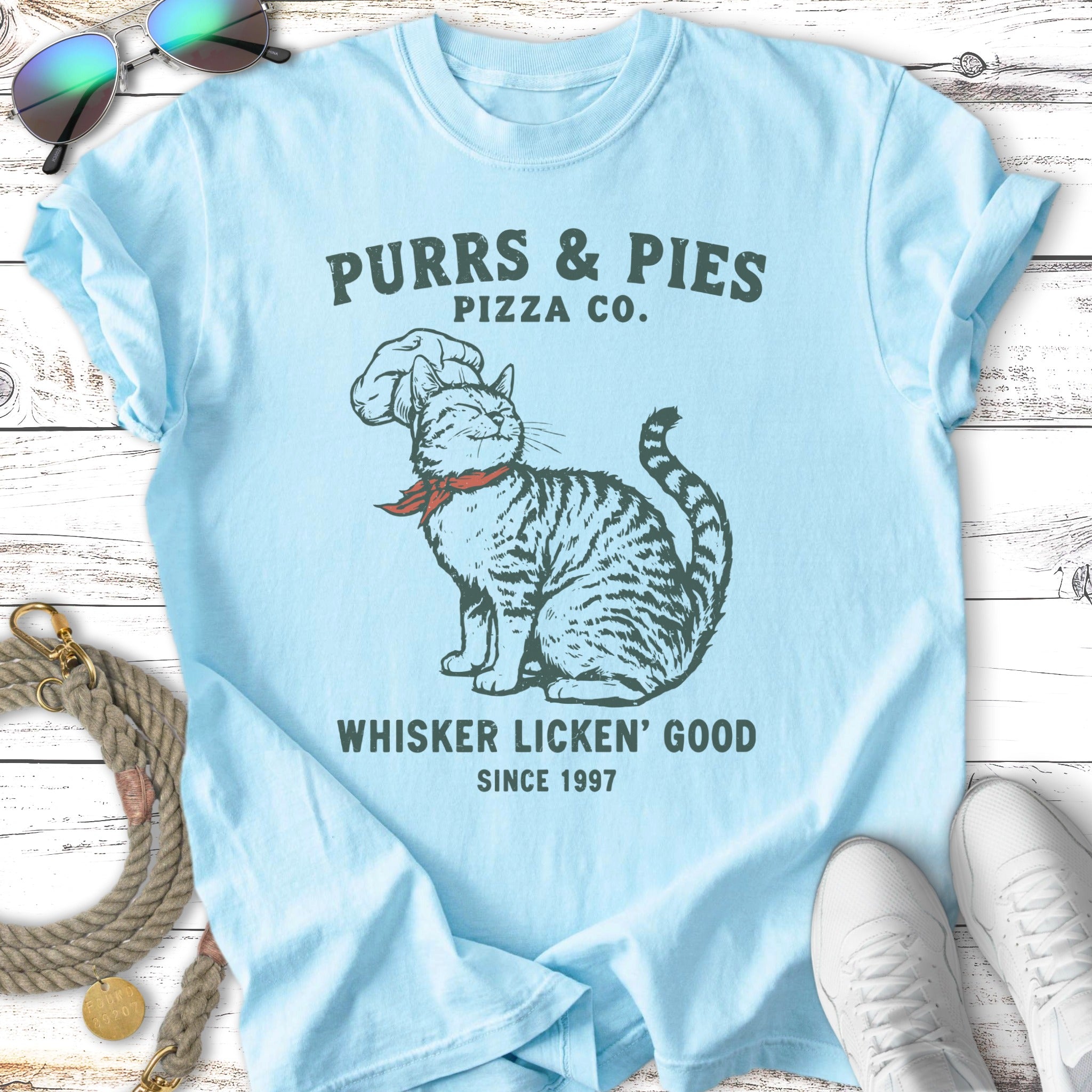 Purrs & Pies Pizza Co. t-shirt with cat wearing chef hat, says "Whisker Licken' Good".