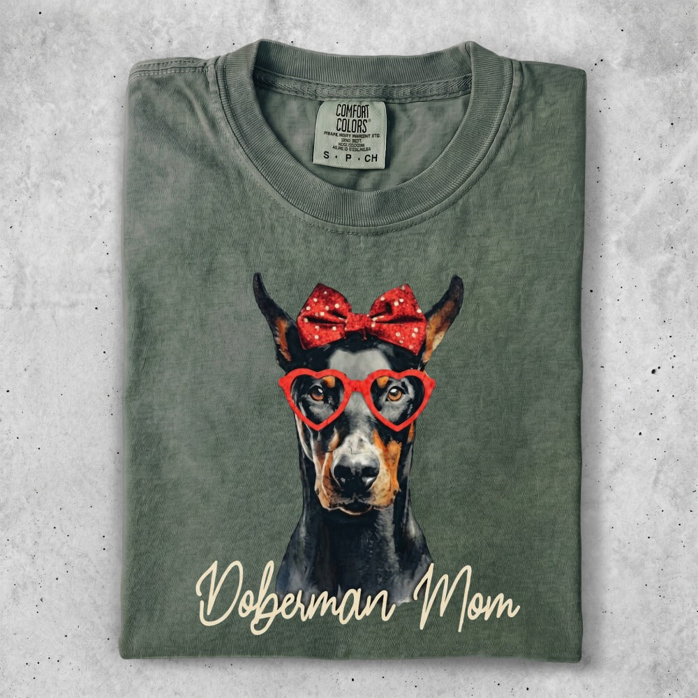 Green t-shirt with Doberman wearing a red bow and heart glasses.