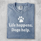 Blue t-shirt with white text: "Life happens. Dogs help." and a paw print.