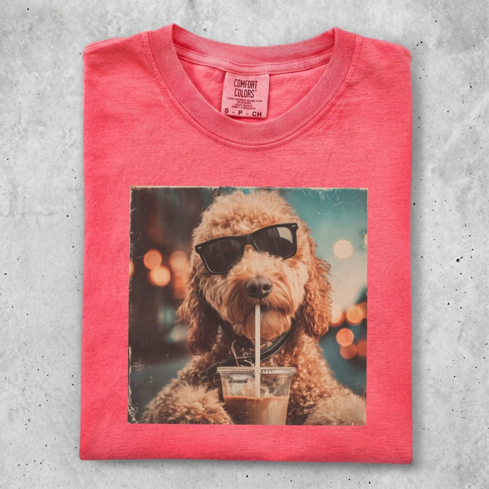 T-shirt with a doodle dog wearing sunglasses drinking from a cup.