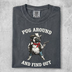 Dark grey t-shirt with a pug wearing a bandana and cowboy hat, holding a gun. Text reads "PUG AROUND AND FIND OUT".