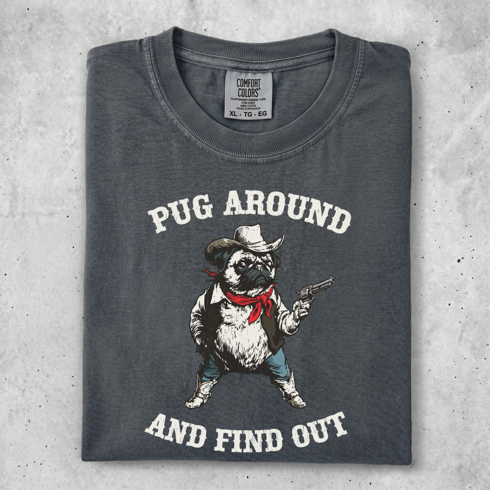 Dark grey t-shirt with a pug wearing a bandana and cowboy hat, holding a gun. Text reads "PUG AROUND AND FIND OUT".