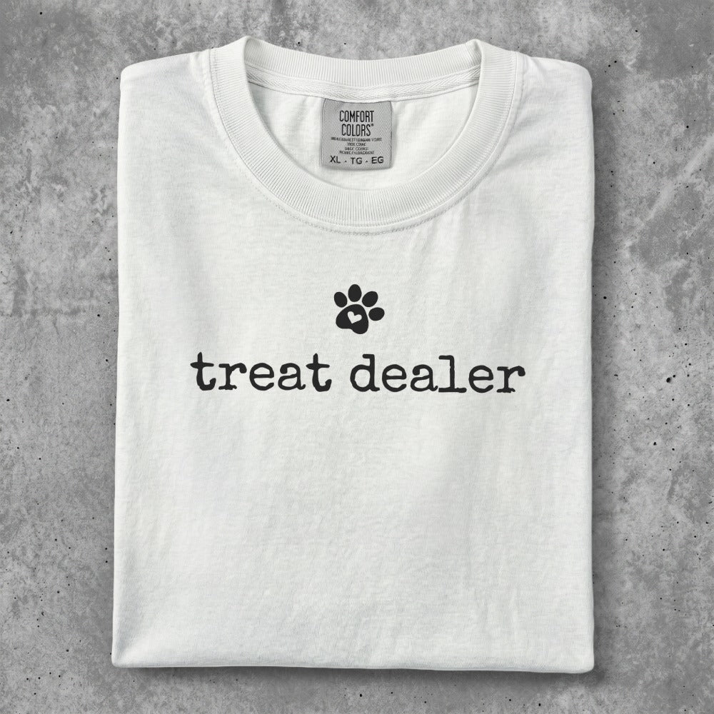 White t-shirt with "treat dealer" and a paw print graphic.