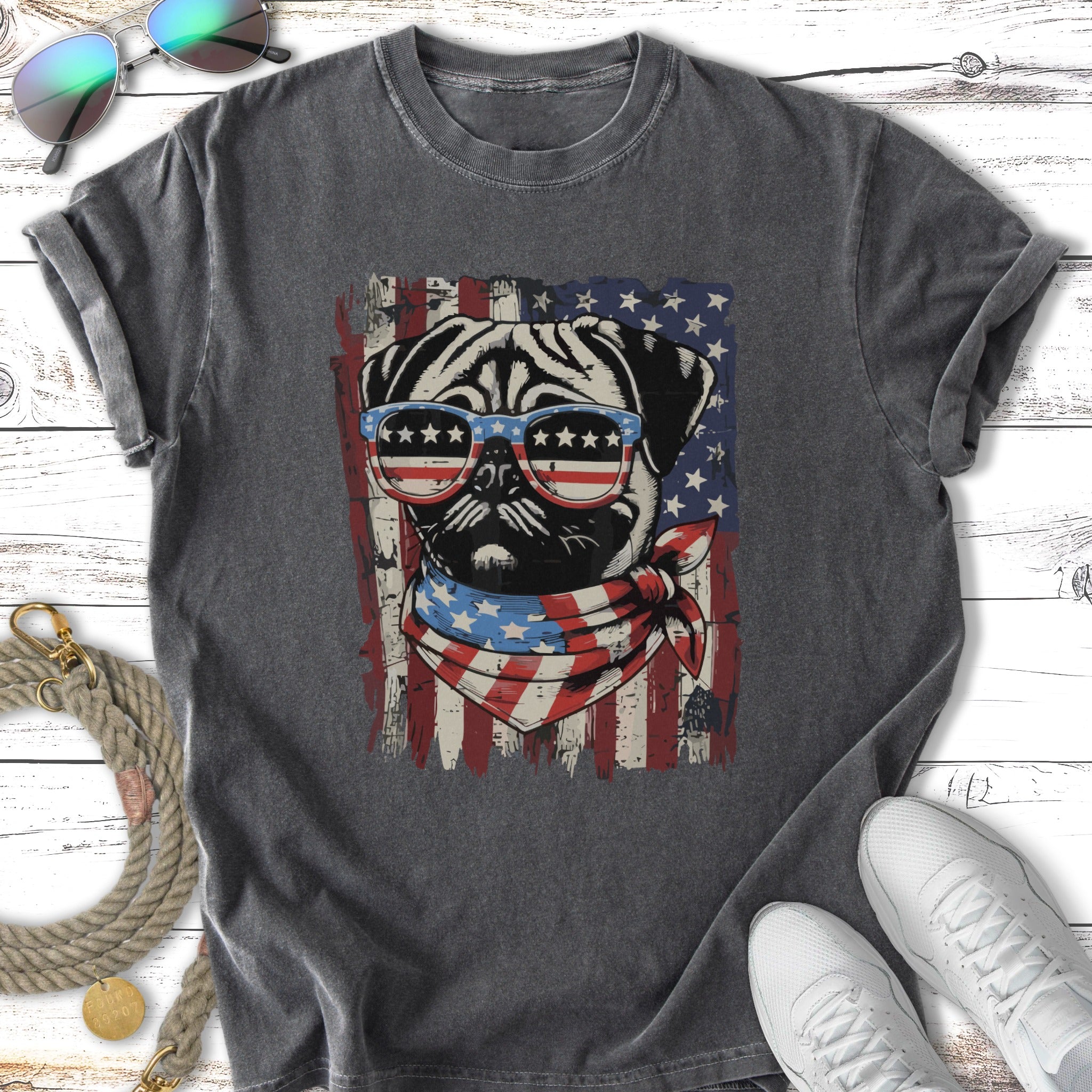 Pug wearing sunglasses and bandana in front of distressed American flag.