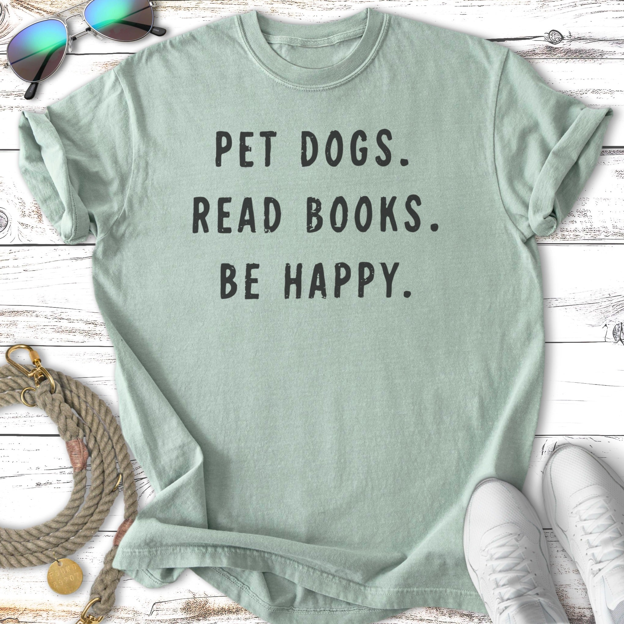 Soft green t-shirt with "Pet dogs. Read books. Be happy." text.