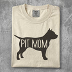 Cream t-shirt with "PIT MOM" text in black silhouette.