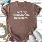 Brown t-shirt with "I left my Bernedoodle to be here." text.