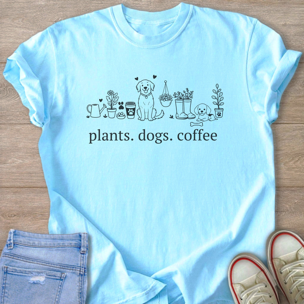 Light blue t-shirt with line art of plants, dogs, and coffee cups, text "plants. dogs. coffee."