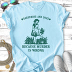 Light blue t-shirt with "Gardening and Dogs" and woman watering plants.