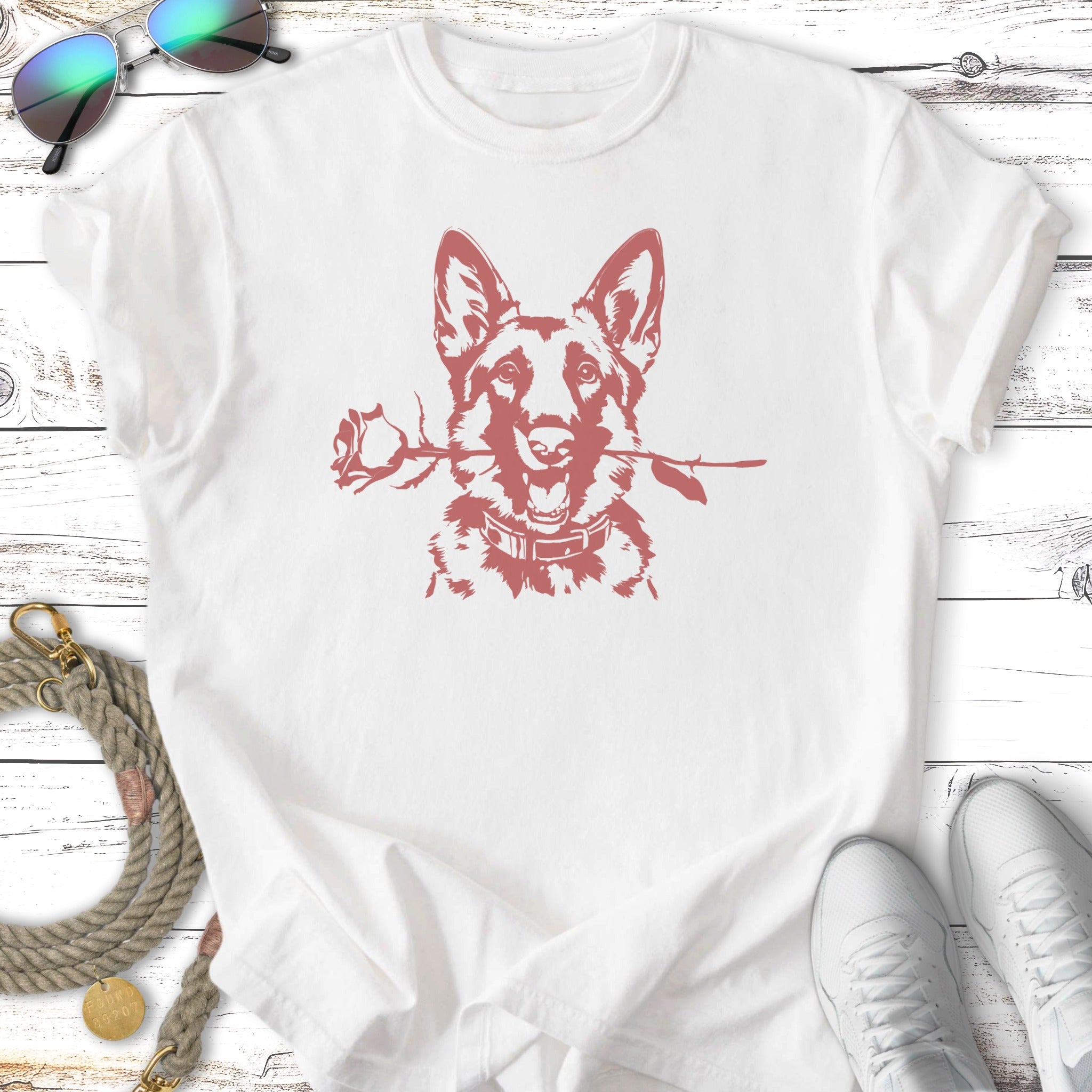 German Shepherd holding a rose in its mouth on a white t-shirt.