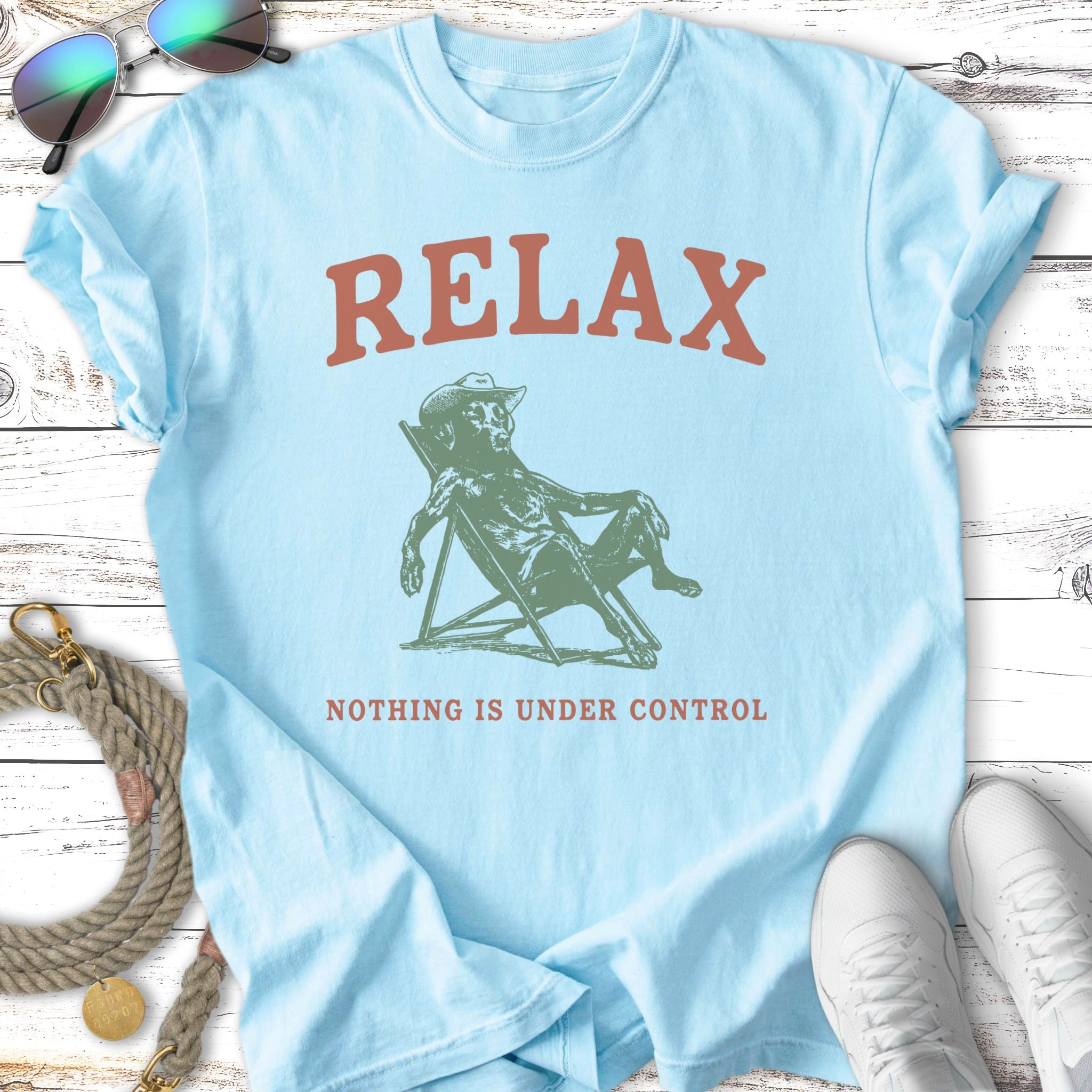 Light blue t-shirt with "RELAX" and a skeleton in a chair.