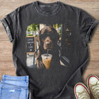 Chocolate lab wearing sunglasses drinks iced coffee with "Coffee Good Days & Labs" sign.