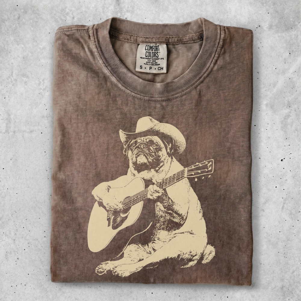T-shirt with distressed tan graphic of a pug wearing a cowboy hat, playing guitar.
