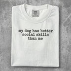 White t-shirt with "my dog has better social skills than me" text.