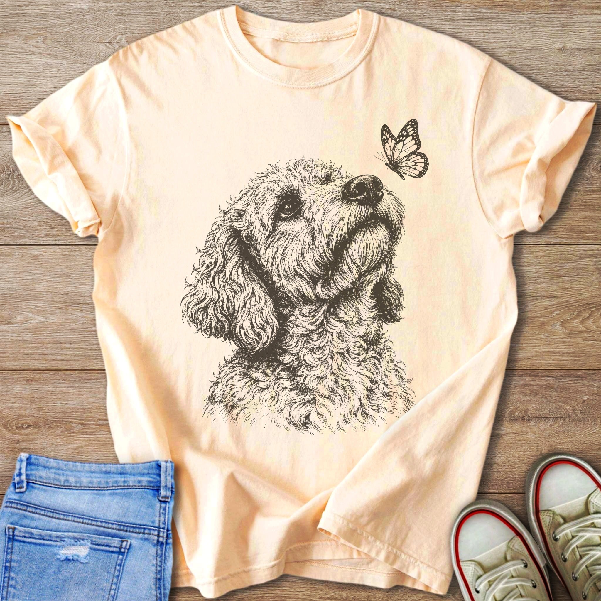 Peach t-shirt with a sketch of a dog looking up at a butterfly.