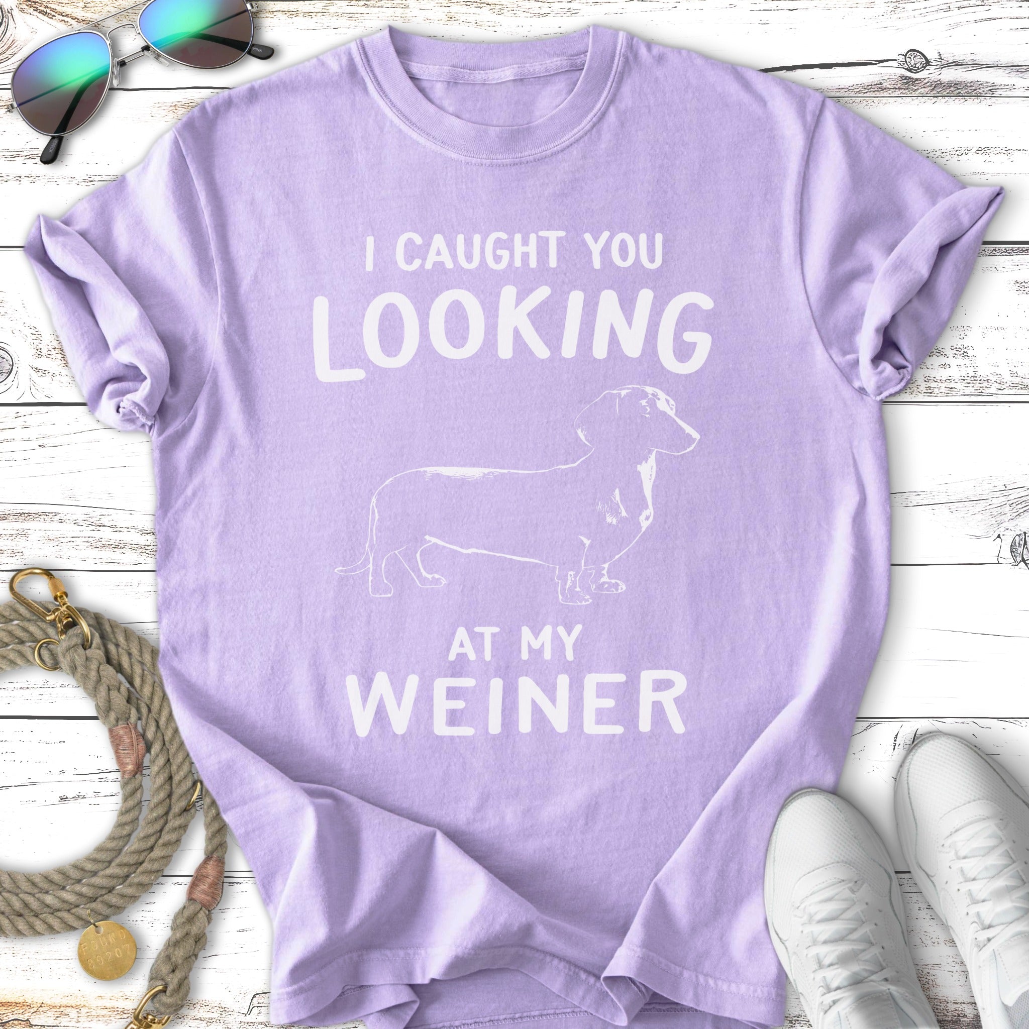 Purple t-shirt with white text "I CAUGHT YOU LOOKING AT MY WEINER" and a dachshund.