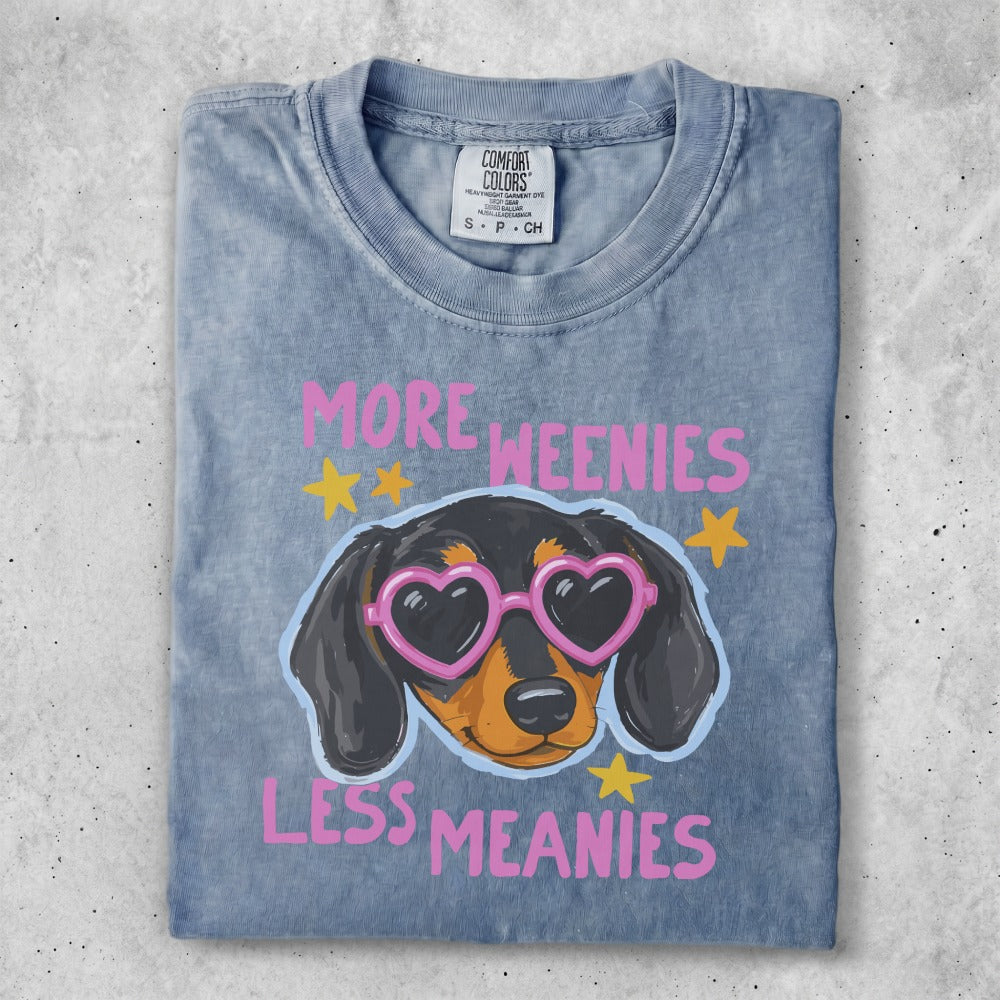 Dachshund wearing heart sunglasses with "MORE WEENIES LESS MEANIES" text.