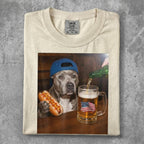 Dog in hat holds hot dog, beer pours into mug with American flag.