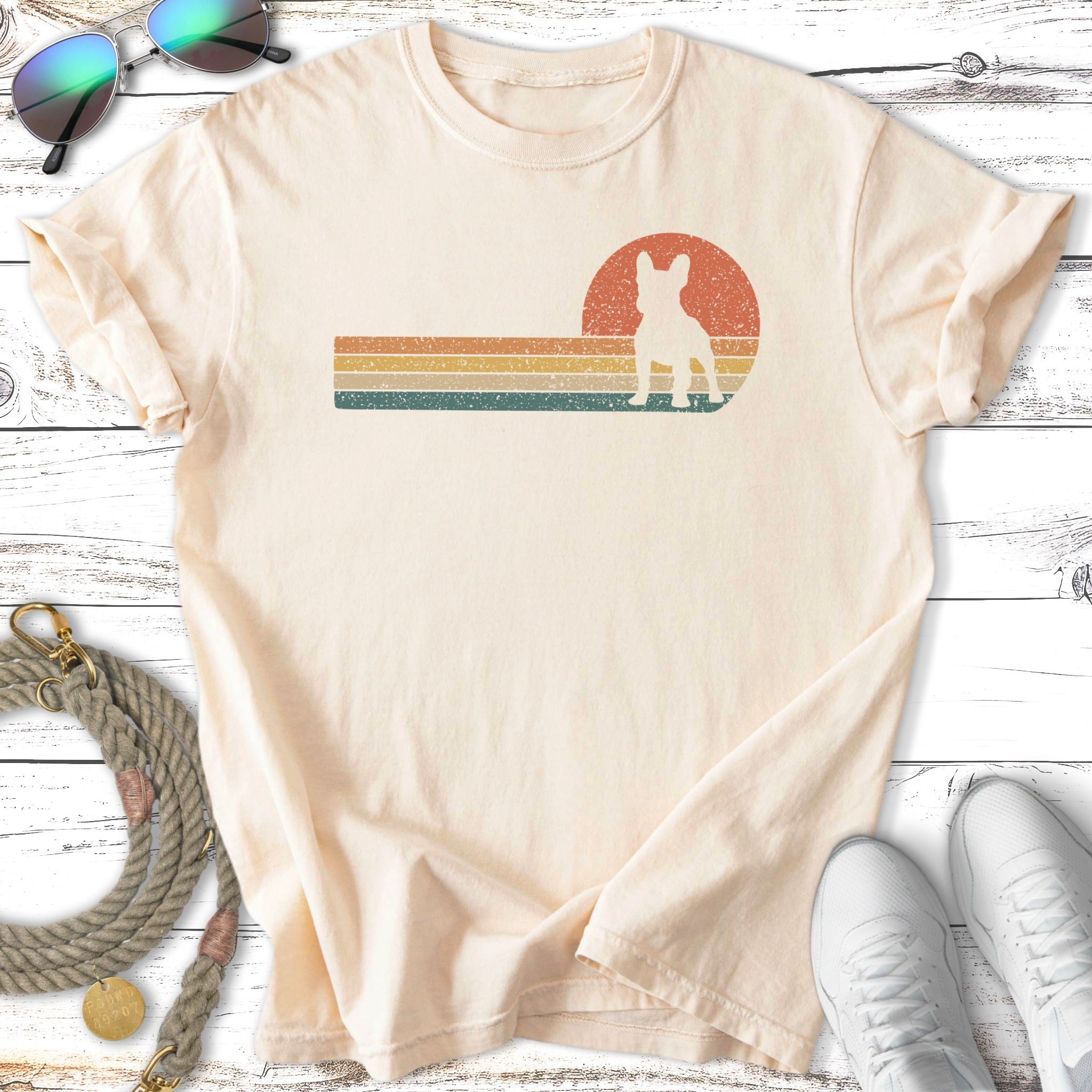 Cream t-shirt with retro French bulldog and sunset graphic.