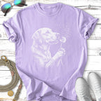 Lavender t-shirt with white line art of a dog holding a dandelion.