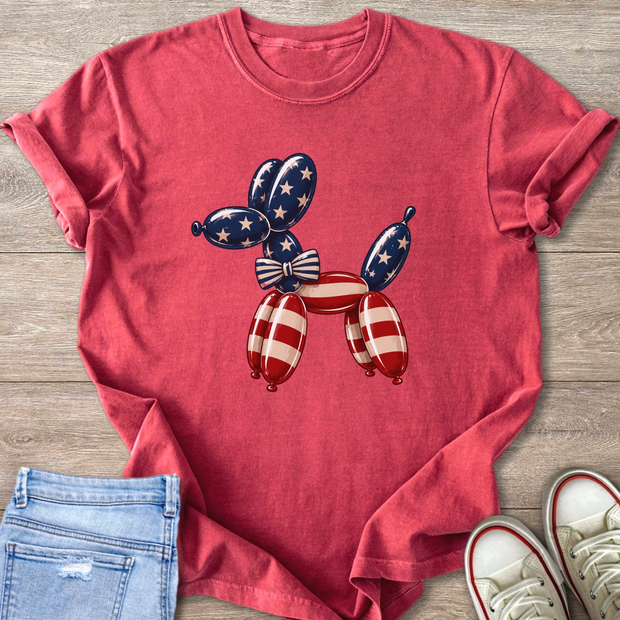 Red t-shirt with a balloon dog graphic in patriotic colors and a striped bow.