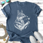 German Shepherd holding a dandelion against a dark blue t-shirt.