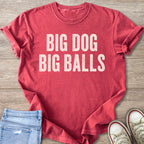Red t-shirt with cream text "BIG DOG BIG BALLS" on a wooden background.