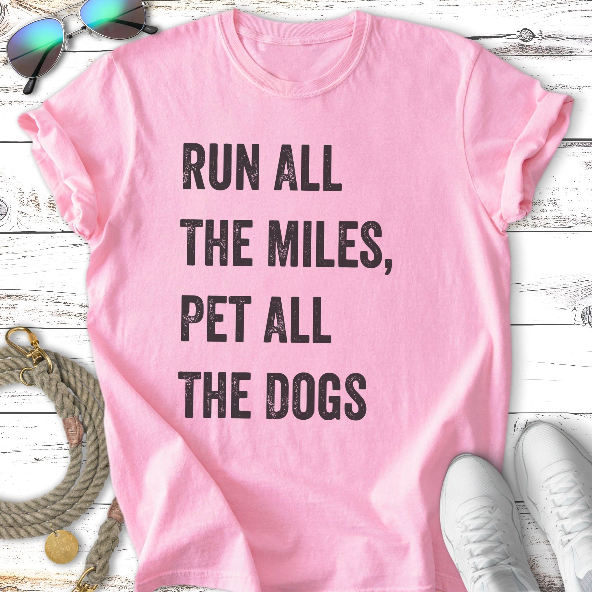 Pink t-shirt with "Run all the miles, pet all the dogs" text.