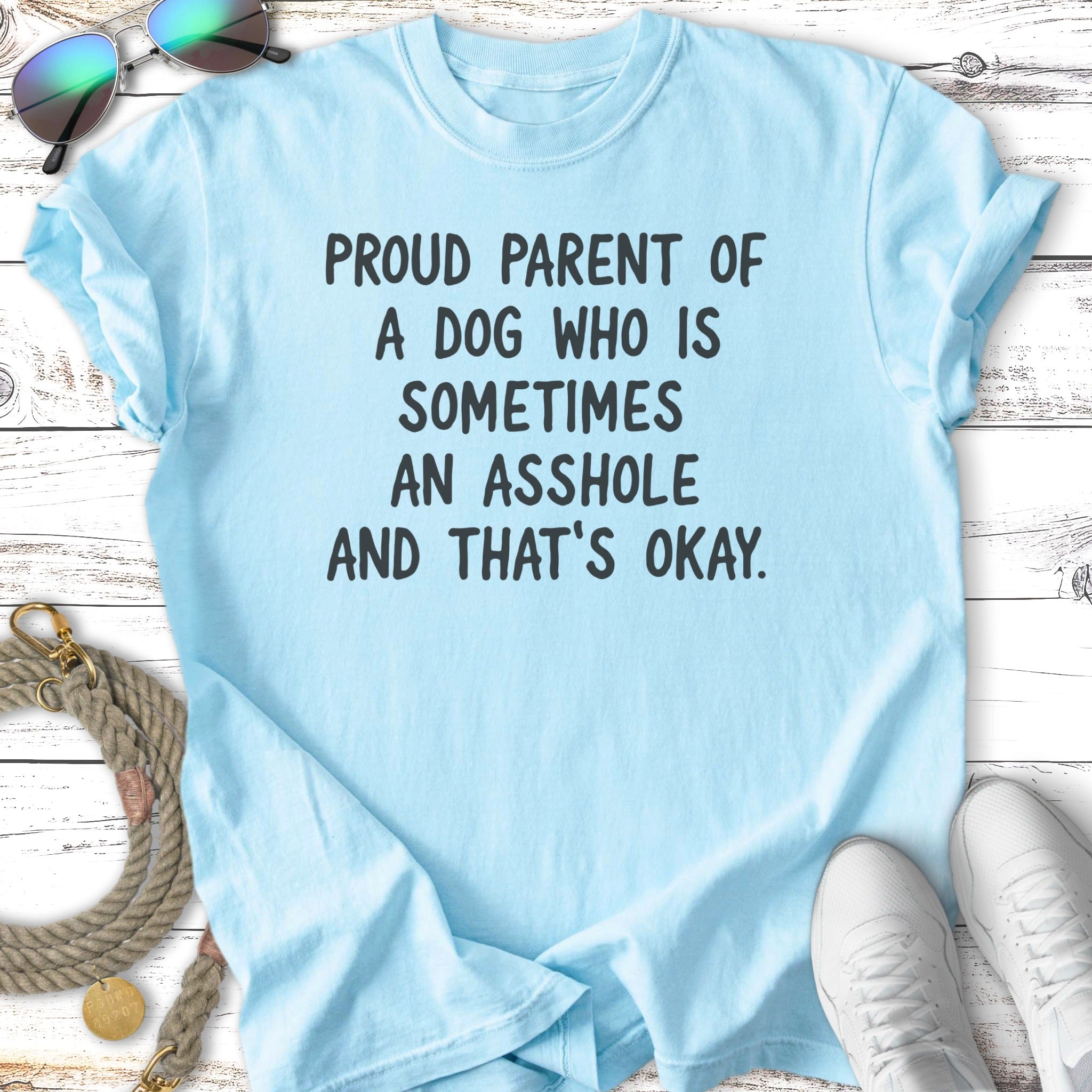 Light blue t-shirt with text "Proud parent of a dog who is sometimes an asshole and that's okay."