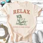 Cream t-shirt with dog lounging in chair, "RELAX NOTHING IS UNDER CONTROL" text.
