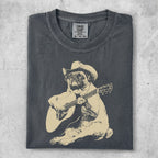 Pug wearing a cowboy hat plays an acoustic guitar.