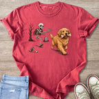 Golden retriever carrying bone runs from a skeleton in a graveyard.