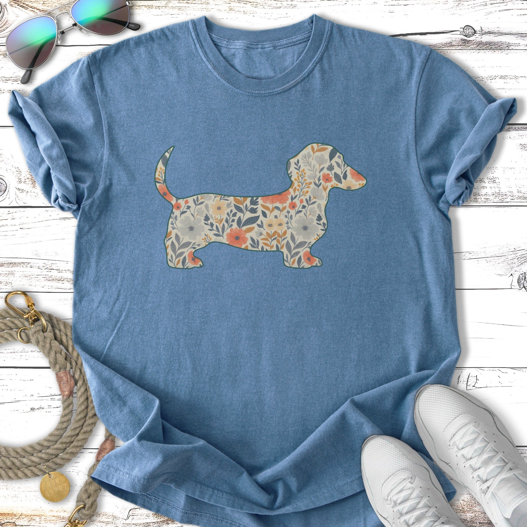 Blue t-shirt with floral dachshund graphic and white sneakers.