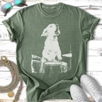 White outline of a dog playing drums on a green t-shirt.