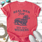Red t-shirt with "Real Men Play With Their Weiners" and a dachshund graphic.