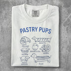 White t-shirt with "Pastry Pups" design featuring illustrated pastries and French names.