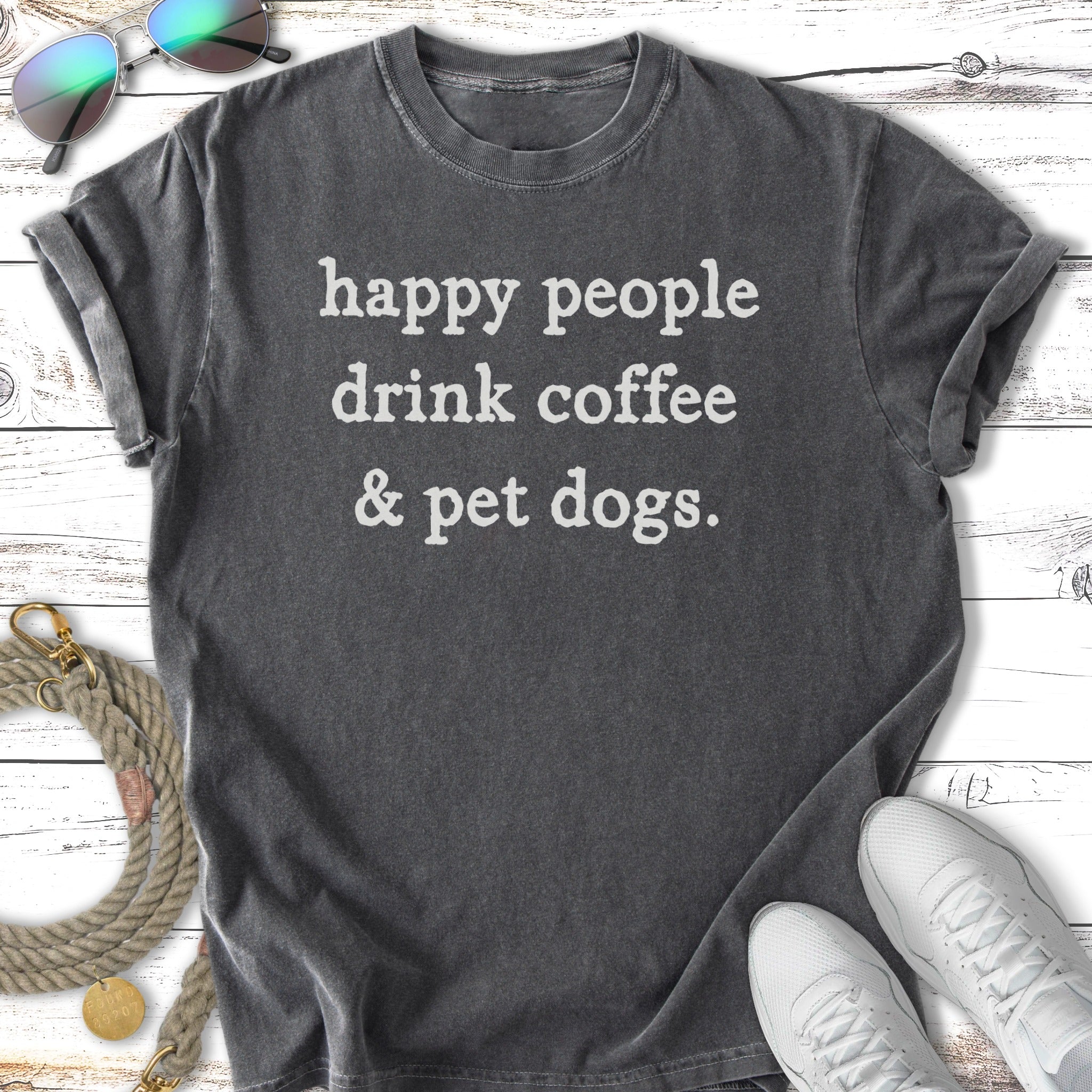 Black t-shirt with white text that reads "happy people drink coffee & pet dogs."