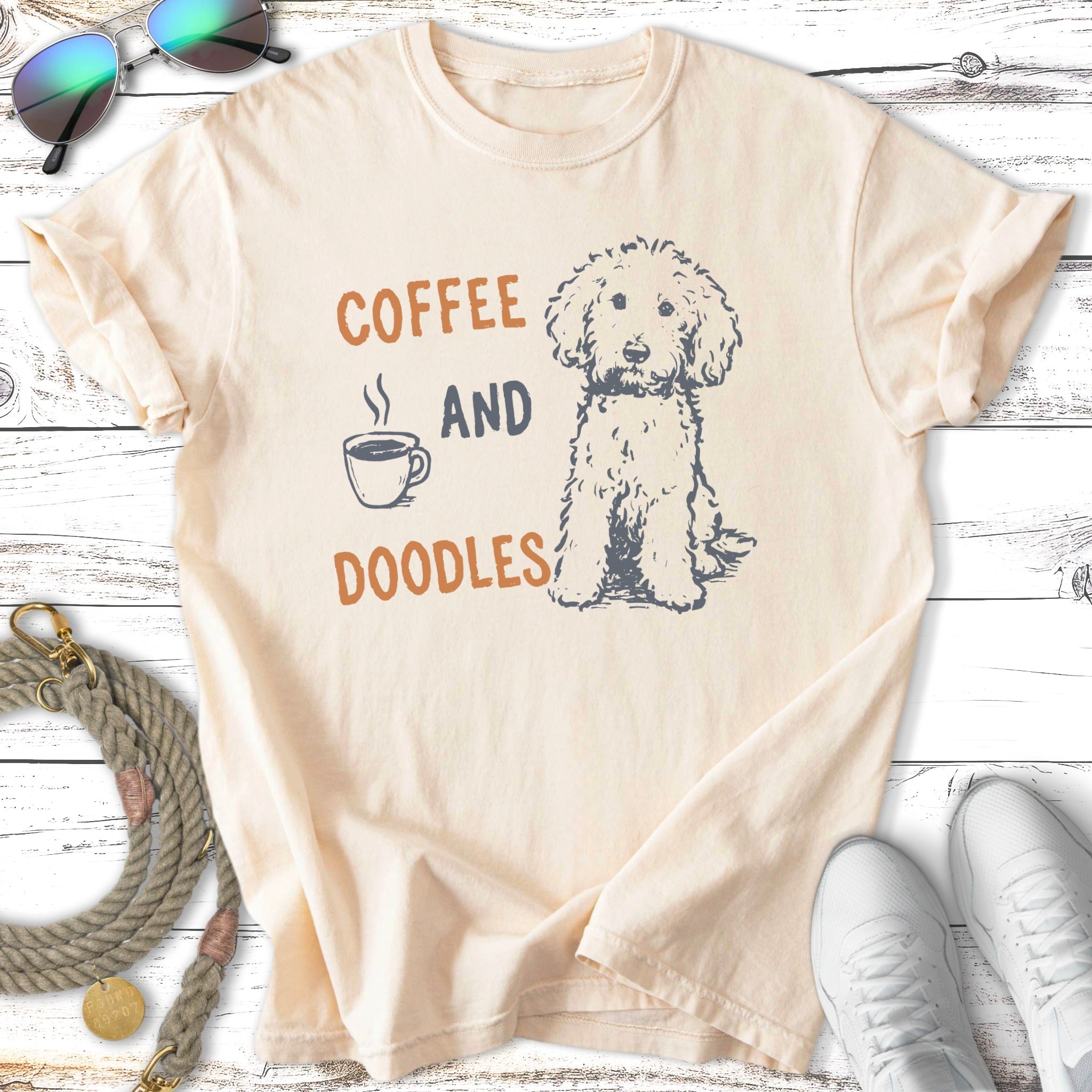 Cream t-shirt with "Coffee and Doodles" text and a doodle dog illustration.
