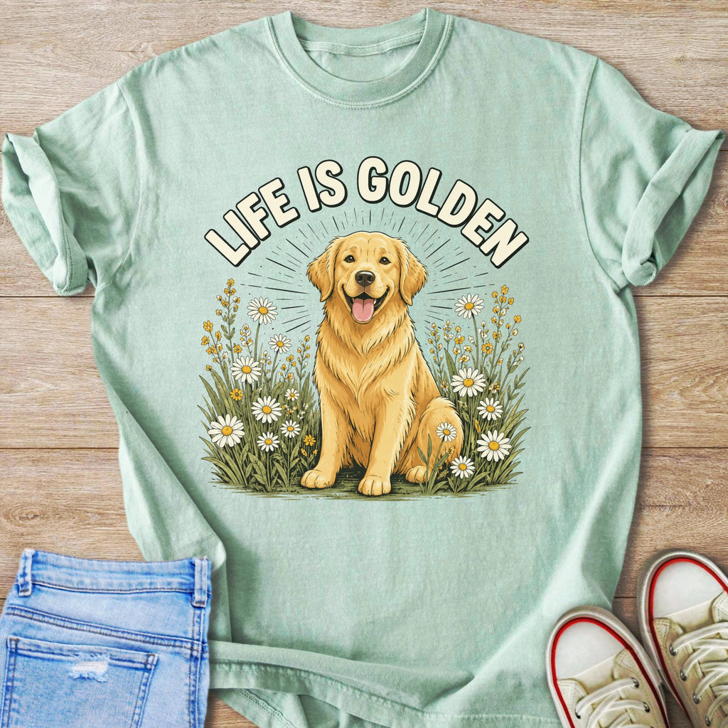 Golden Retriever with "LIFE IS GOLDEN" text among daisies on a light green t-shirt.