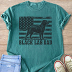 Green t-shirt with black distressed American flag and black lab graphic and text.