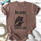 Brown t-shirt with black graphic of a cat and text "become ungovernable".