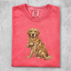 Golden retriever wearing "I ❤️ MOM" tattoo on a coral t-shirt.