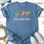 Blue t-shirt with colorful peace sign, heart, and paw print graphic and text.