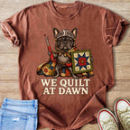 French bulldog in armor holding sewing tools and quilt, says "We Quilt at Dawn".